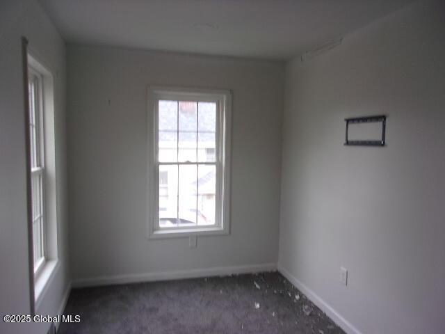 spare room with dark carpet