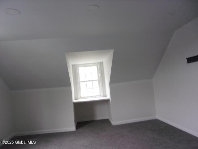 bonus room featuring lofted ceiling and dark carpet