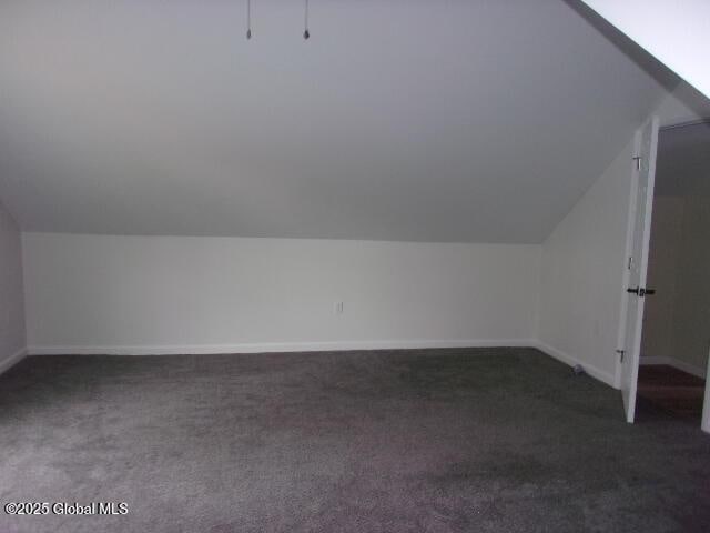 additional living space with lofted ceiling and dark carpet