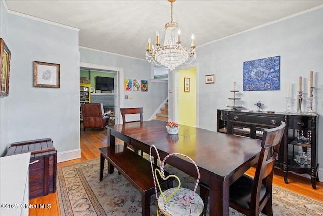 dining room with crown molding, light hardwood / wood-style floors, and a chandelier