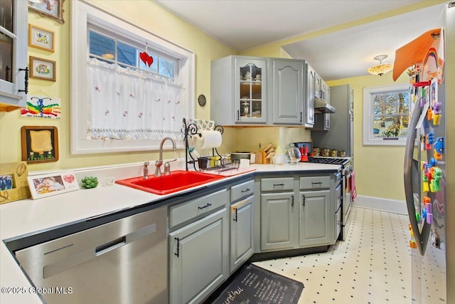 kitchen featuring a healthy amount of sunlight, appliances with stainless steel finishes, sink, and gray cabinetry