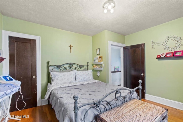 bedroom with wood-type flooring and a textured ceiling