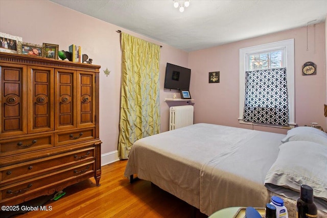 bedroom featuring radiator and light wood-type flooring