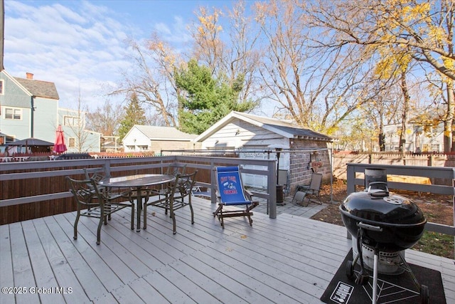 wooden deck featuring an outdoor structure and area for grilling