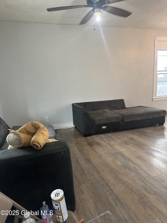 living room with ceiling fan, dark hardwood / wood-style floors, and a textured ceiling