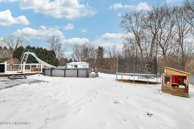 snowy yard featuring a trampoline