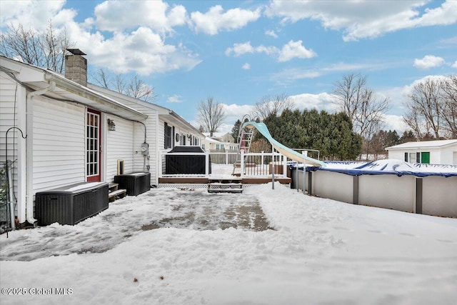 yard covered in snow with a covered pool