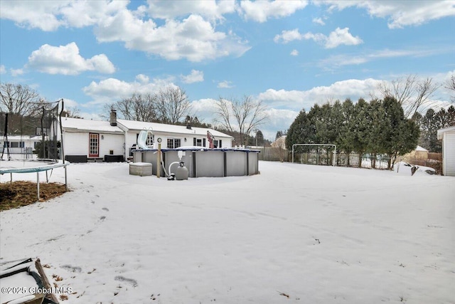 yard covered in snow with a trampoline