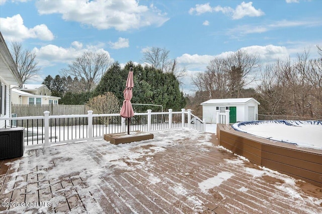 snow covered deck with a shed