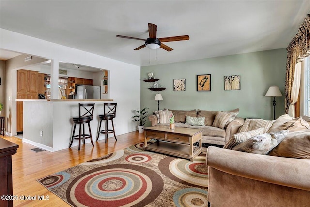 living room with ceiling fan and light hardwood / wood-style floors