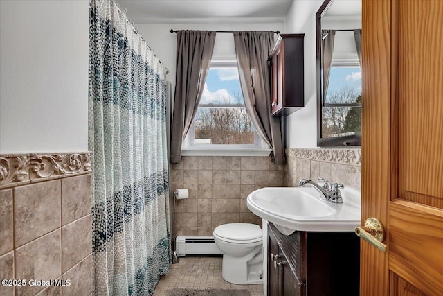 bathroom with tile walls, vanity, a baseboard radiator, and toilet