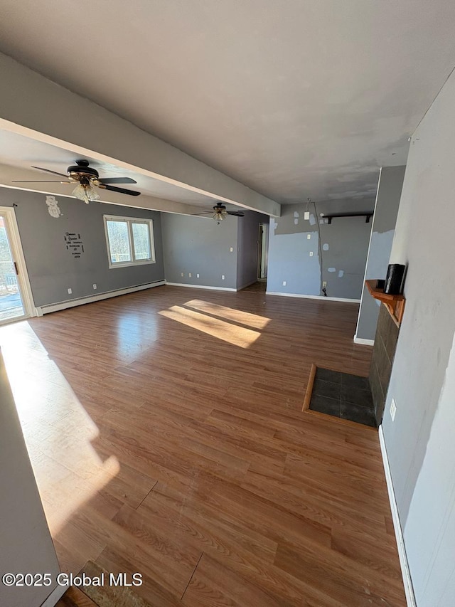 unfurnished living room with a baseboard radiator, dark wood-type flooring, and ceiling fan