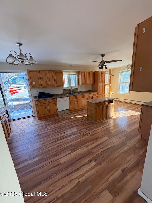 kitchen featuring dishwasher, a kitchen island, dark hardwood / wood-style flooring, and decorative light fixtures