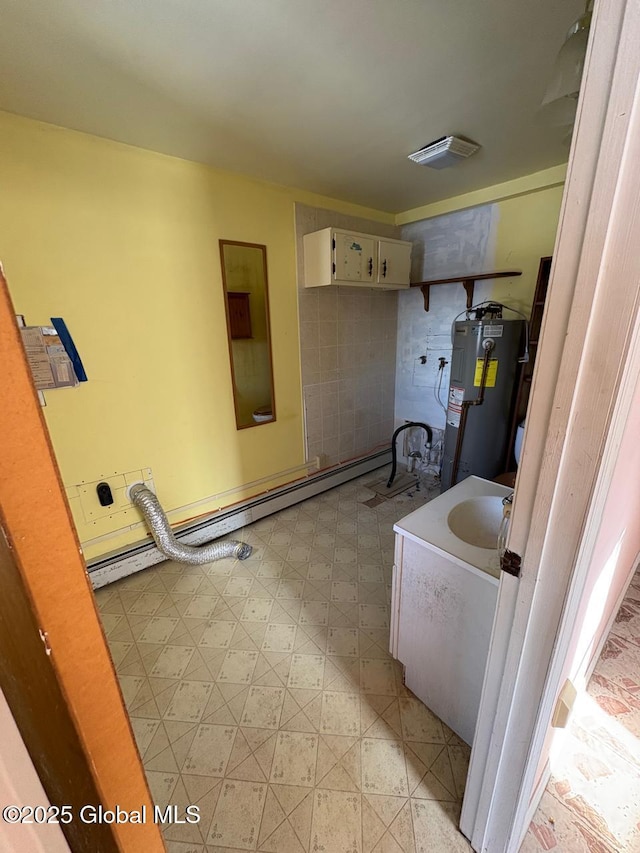 bathroom featuring water heater and a baseboard heating unit