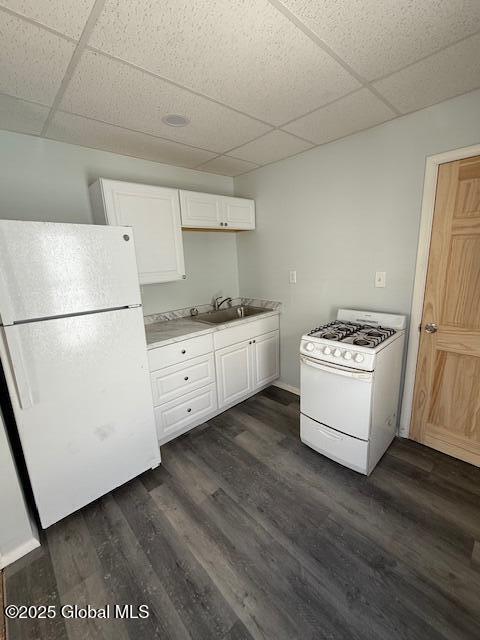 kitchen featuring white cabinetry, sink, white appliances, and dark wood-type flooring