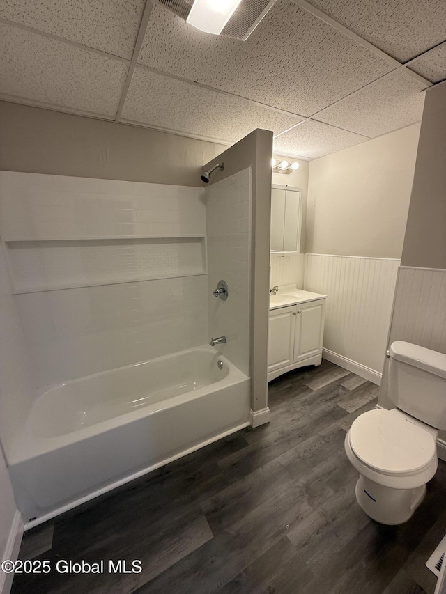 full bathroom with toilet, bathing tub / shower combination, a paneled ceiling, vanity, and hardwood / wood-style floors