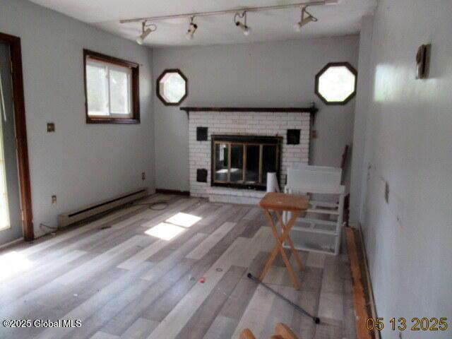 43 Bennett Rd, Queensbury, NY 12804 - living room with a baseboard radiator, a fireplace, wood finished floors, and rail lighting