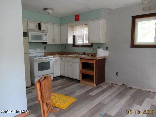 43 Bennett Rd, Queensbury, NY 12804 - kitchen featuring white appliances, a sink, light wood-style floors, and white cabinetry