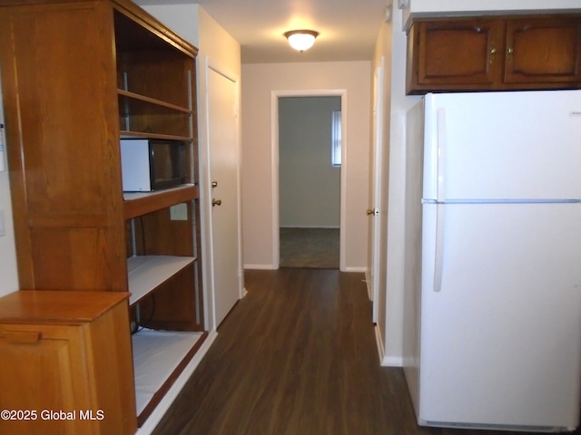 corridor with dark wood-style floors and baseboards