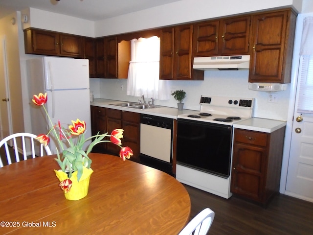 kitchen featuring under cabinet range hood, white appliances, light countertops, and a sink