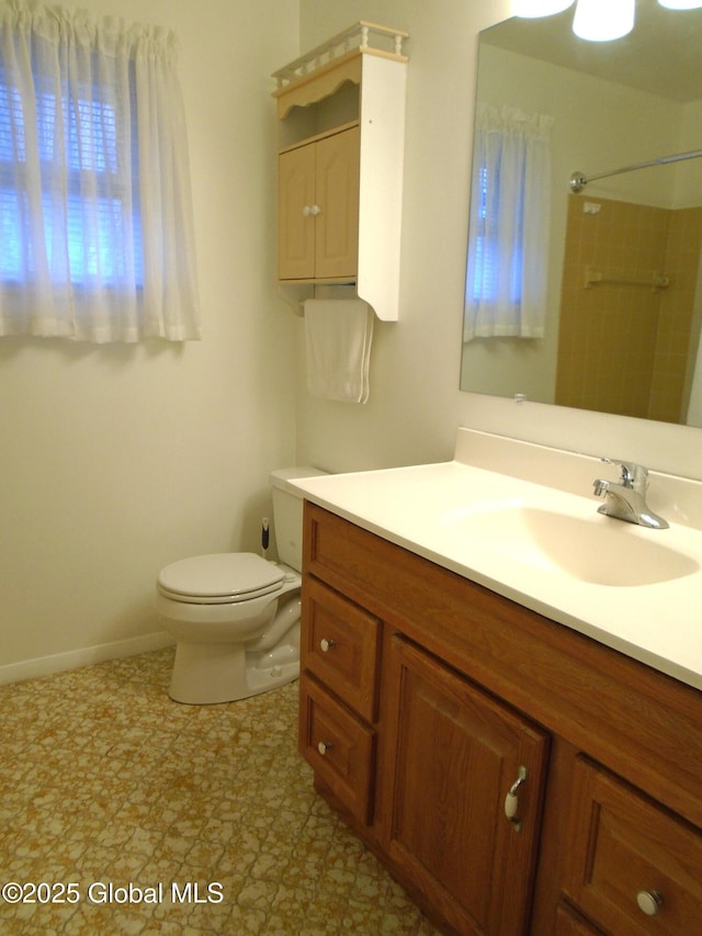 full bath featuring a shower, baseboards, toilet, and vanity