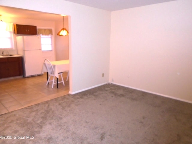 interior space featuring tile patterned flooring, carpet flooring, baseboards, and a sink