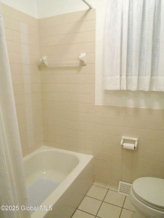 bathroom featuring visible vents, toilet, shower / tub combo with curtain, tile walls, and tile patterned flooring