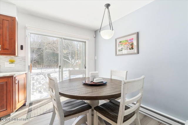 dining area featuring a baseboard heating unit and light wood-type flooring