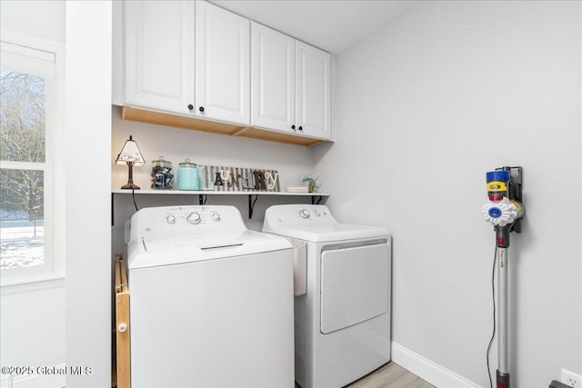 washroom with cabinets and washing machine and dryer