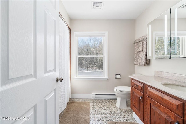 bathroom with vanity, baseboard heating, and toilet