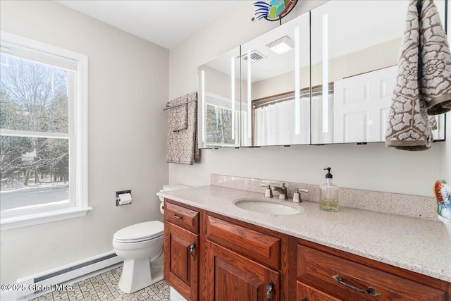 bathroom featuring vanity, a wealth of natural light, and a baseboard heating unit