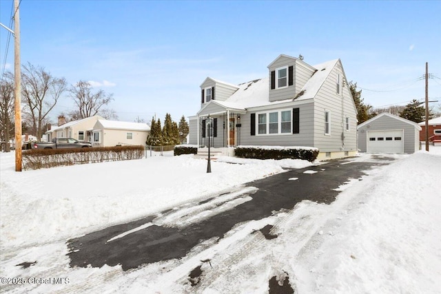 cape cod house featuring a garage and an outbuilding