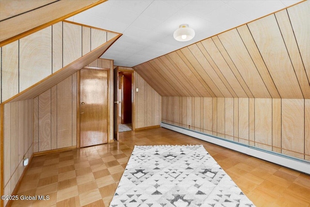 additional living space with lofted ceiling, wooden walls, and baseboard heating