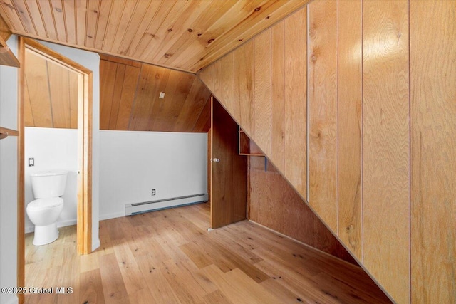 additional living space featuring a baseboard heating unit, wooden ceiling, and light wood-type flooring