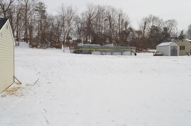 snowy yard featuring a shed