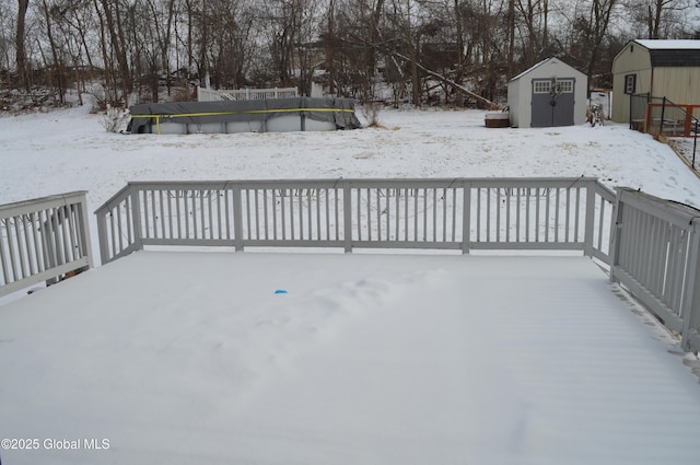 snow covered deck with a shed