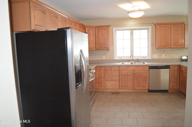 kitchen featuring tasteful backsplash, sink, stainless steel appliances, and light brown cabinetry