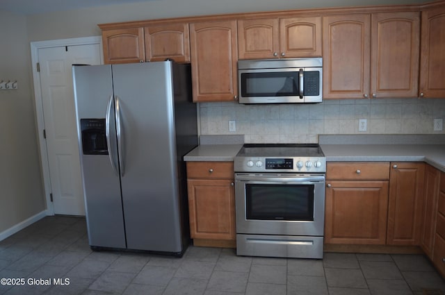 kitchen featuring stainless steel appliances, decorative backsplash, and light tile patterned floors