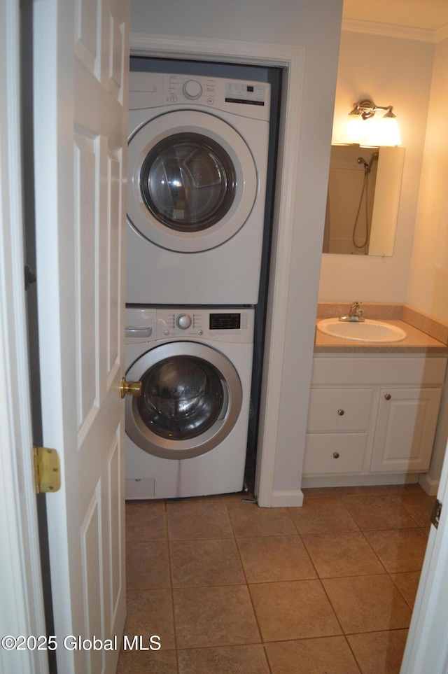 laundry area with stacked washer / drying machine, light tile patterned floors, ornamental molding, and sink