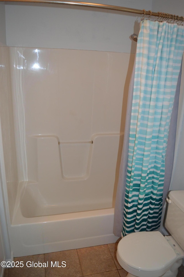 bathroom with shower / tub combo with curtain, tile patterned floors, and toilet