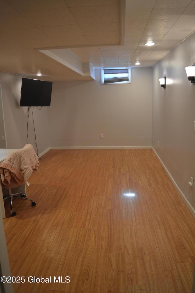 basement with a drop ceiling and wood-type flooring