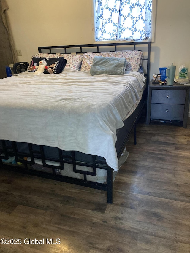 bedroom with dark wood-type flooring