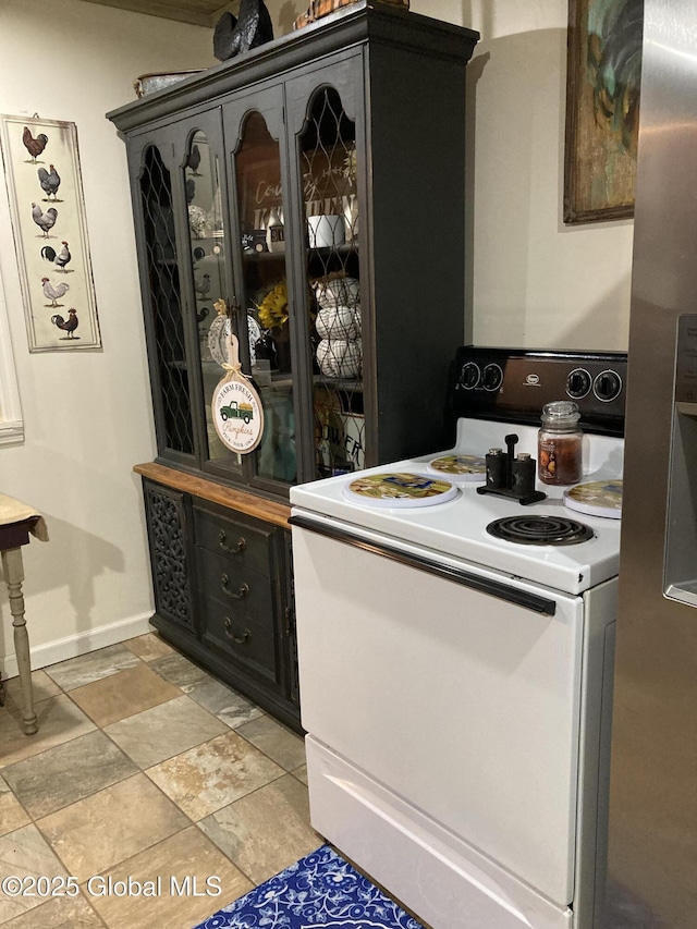 bar with white electric stove and baseboards