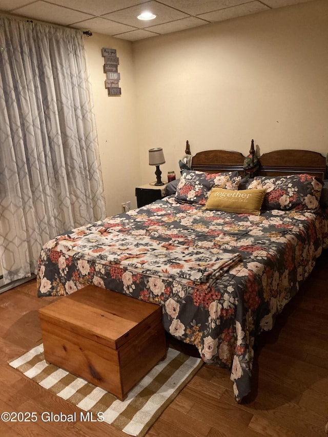 bedroom featuring wood finished floors and a paneled ceiling