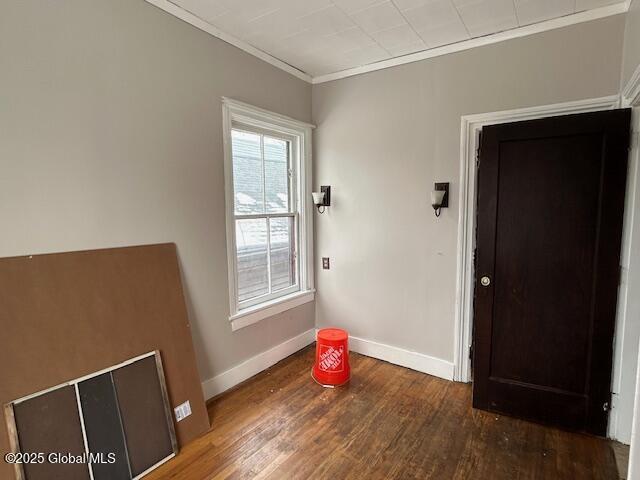 spare room with crown molding and wood-type flooring