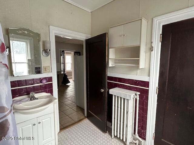 bathroom featuring tile patterned floors, radiator heating unit, vanity, and ornamental molding