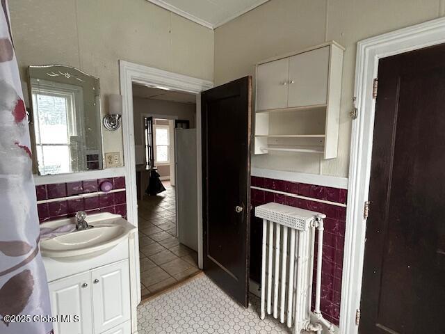 bathroom with tile patterned floors, radiator heating unit, and vanity