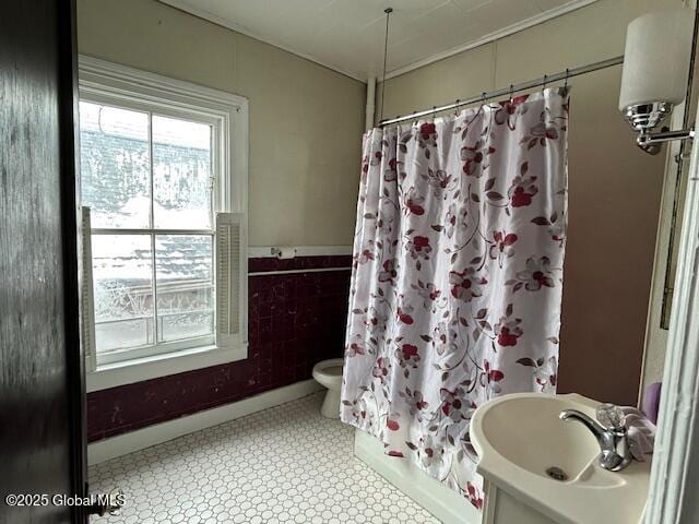 full bathroom with sink, shower / tub combo with curtain, and toilet