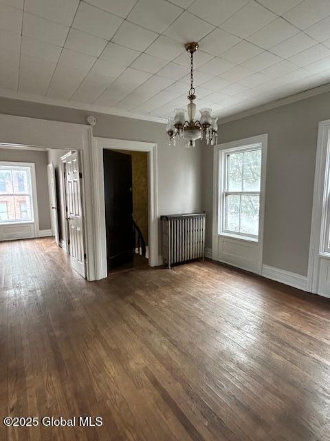 interior space featuring crown molding, dark hardwood / wood-style floors, and an inviting chandelier