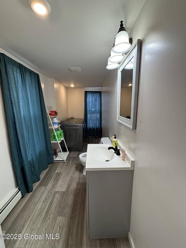 86 Reid St, Fort Plain, NY 13339 - bathroom with vanity, wood finished floors, baseboards, toilet, and baseboard heating